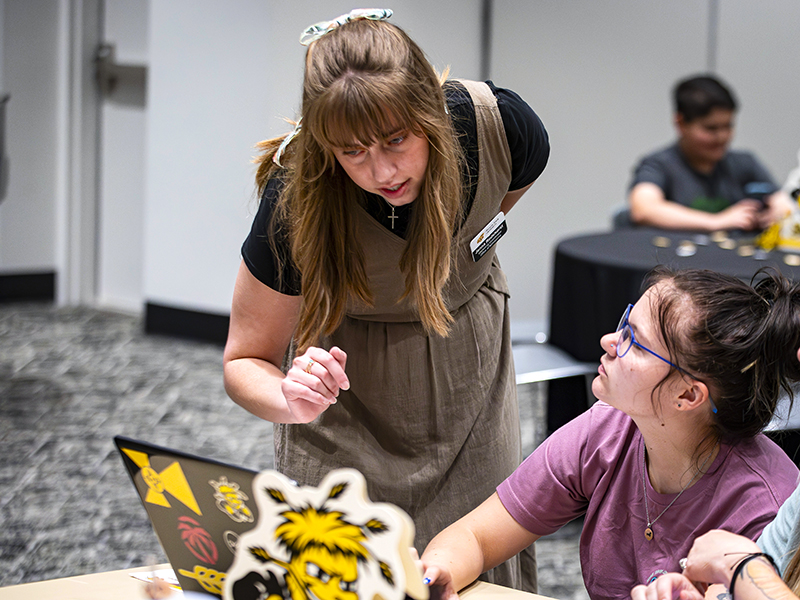 Jenna Rodehorst, Marking Coordinator, assists a student with their application.