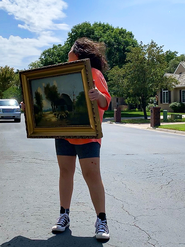 Ann with a painting she bought at an estate sale in Wichita.