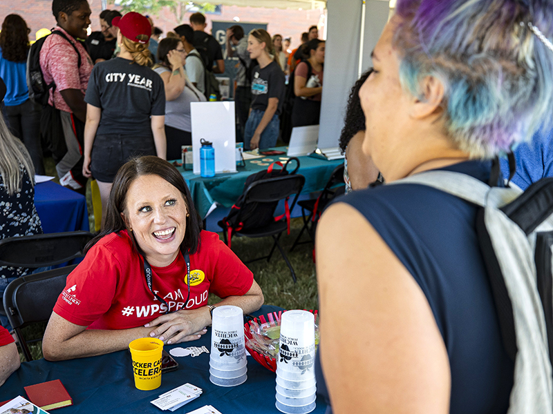 A representative from Wichita Public Schools talks with students at the Shocker Career Accelerator Root Beer Kegger.