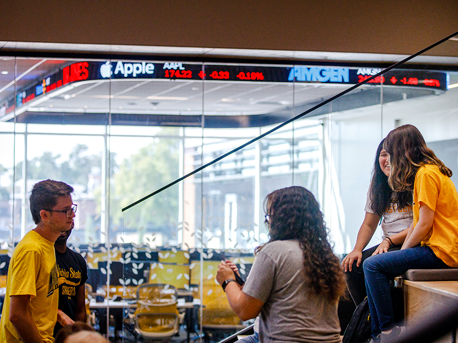 Students chatting outside of the Koch Global Trading Center at Wichita State's Barton School of Business.