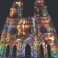 Cathédrale Sainte-Croix d’Orléans at night with images and colors projected onto it.