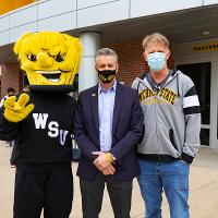 Wu stands with President Rick Muma and First Gentleman Rick Case to celebrate the bash before they grab some cupcakes.