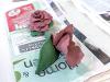 Detailed image of two paper clay roses sitting on newspaper.