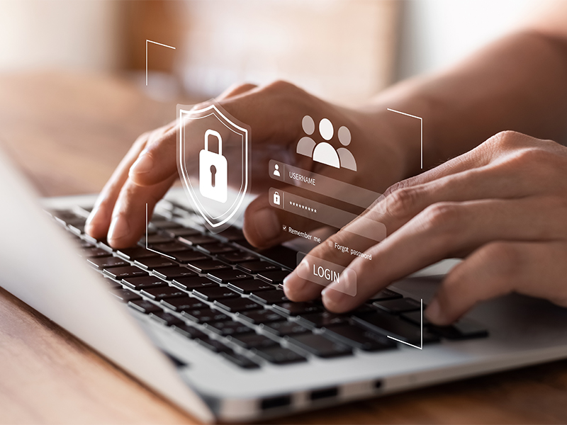 Photo of typing on the computer with a login screen overlayed onto the keyboard