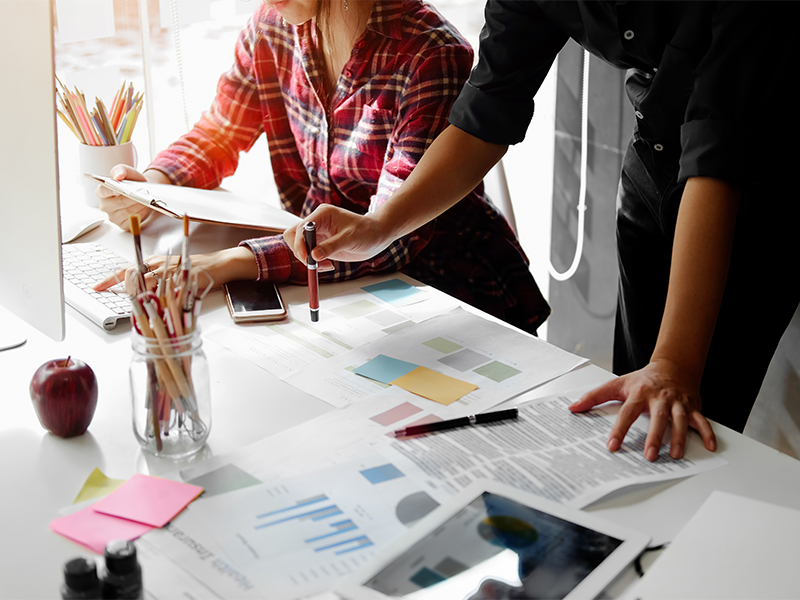 Photo of two people discussing branding documents