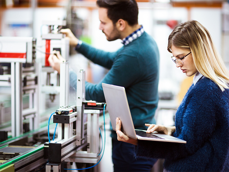 Photo of two people testing a machine and gathering data