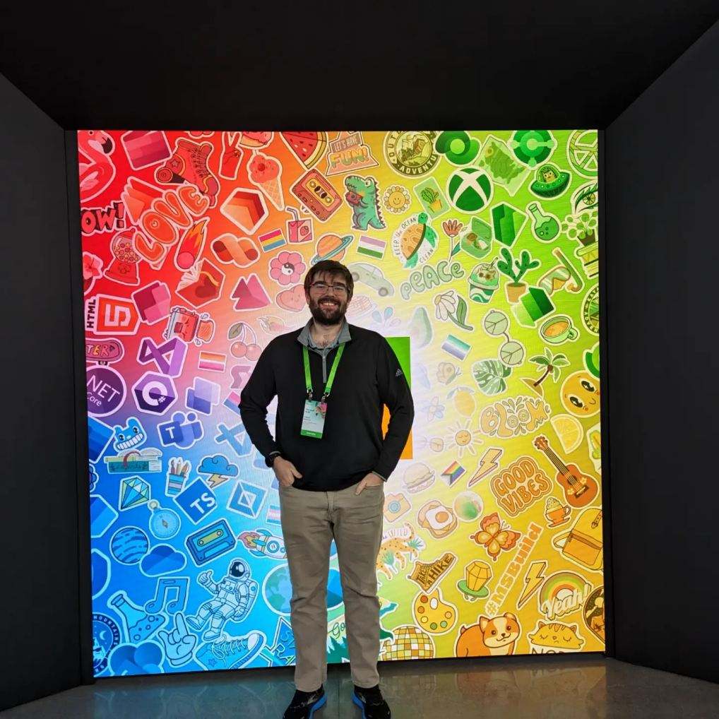 Photo of Trevor Rietcheck in front of a banner with Microsoft logos