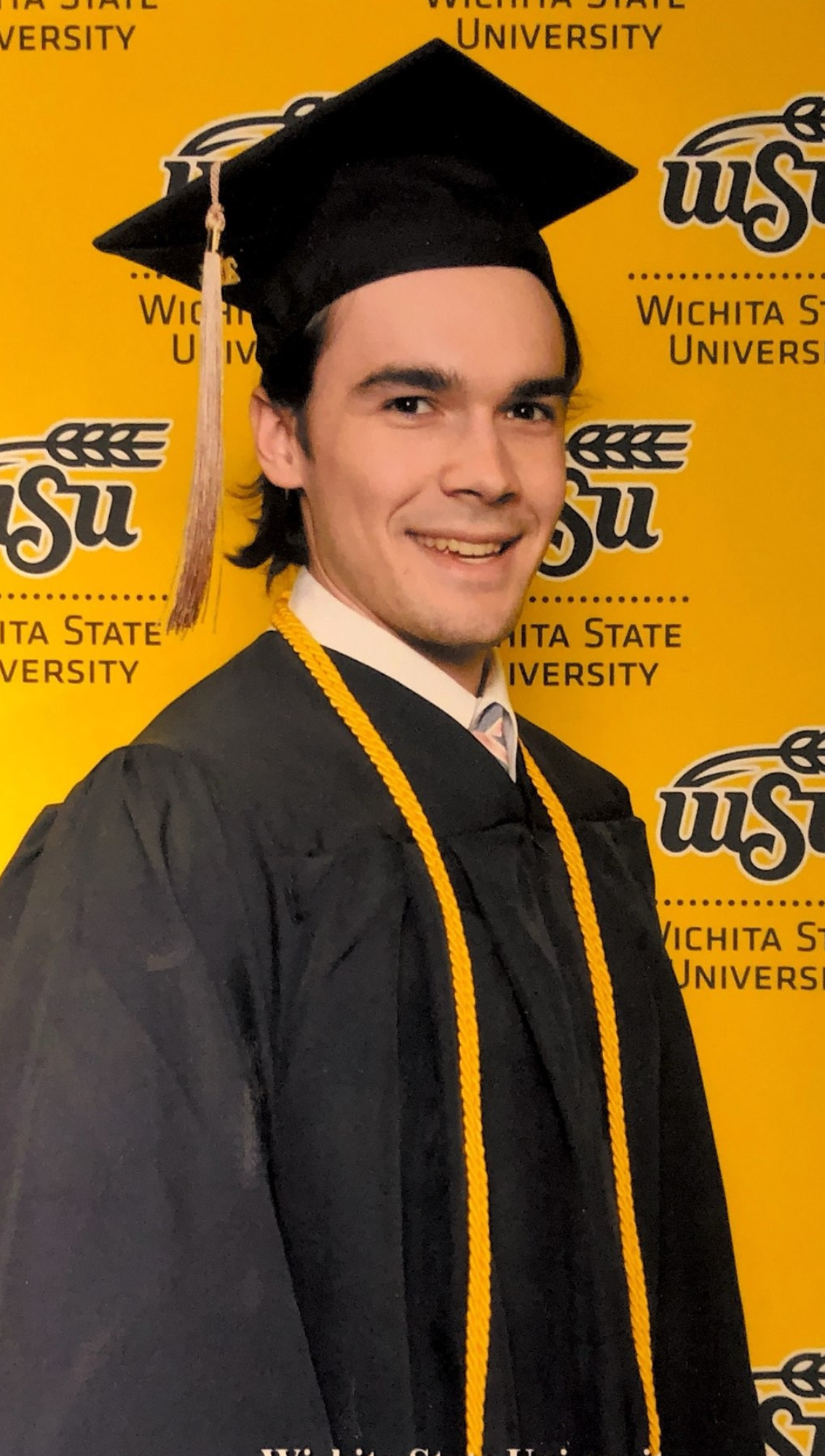 Photo of Logan Quinn in a graduation cap and gown