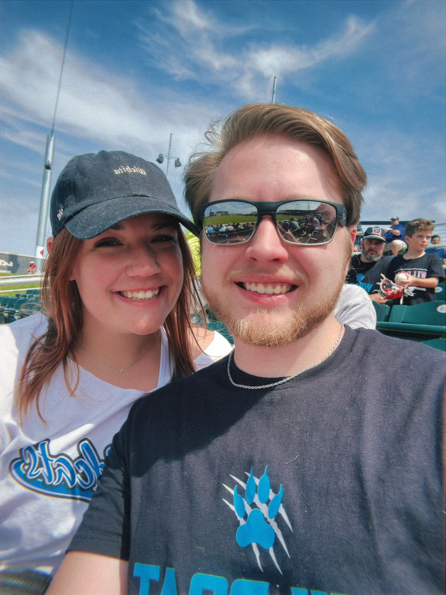 Photo of Alex Harms and one other sitting in a sports stadium.