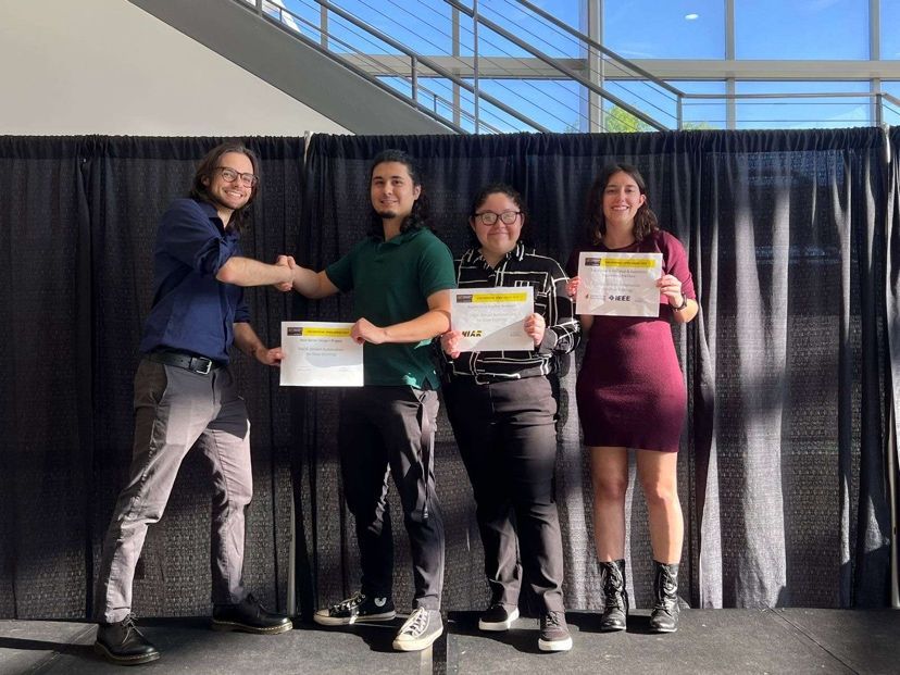 Photo of Emily Knudsen and her senior design project team recieving an award at the Wichita State Engineering Open House