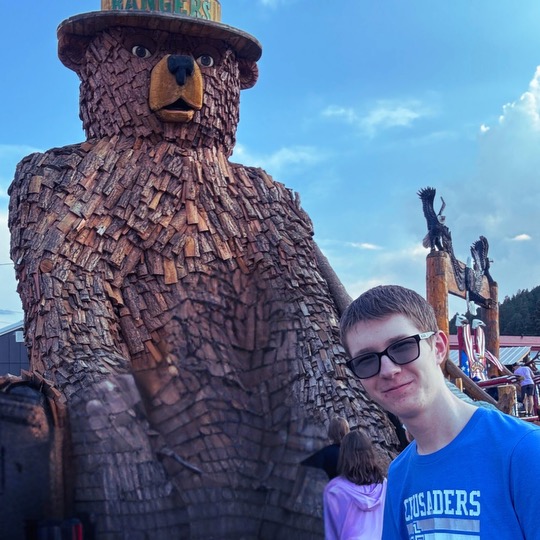 Photo of Connor Beard in front of a bear statue