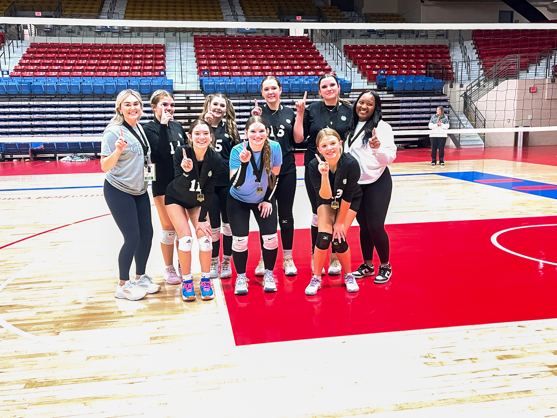 Photo of Tayana Martin with the vollyball team she coaches