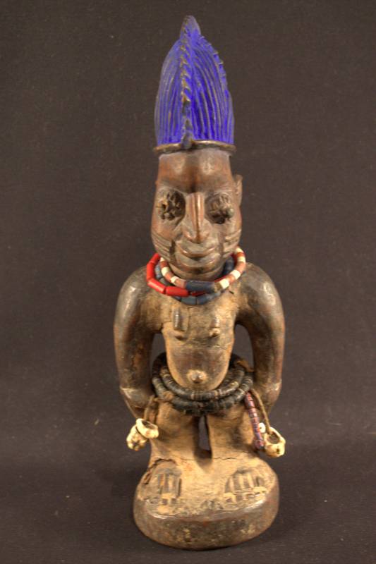 Wooden Figure Standing figure with blue dye on the top of the head and beads decorating the neck and waist.