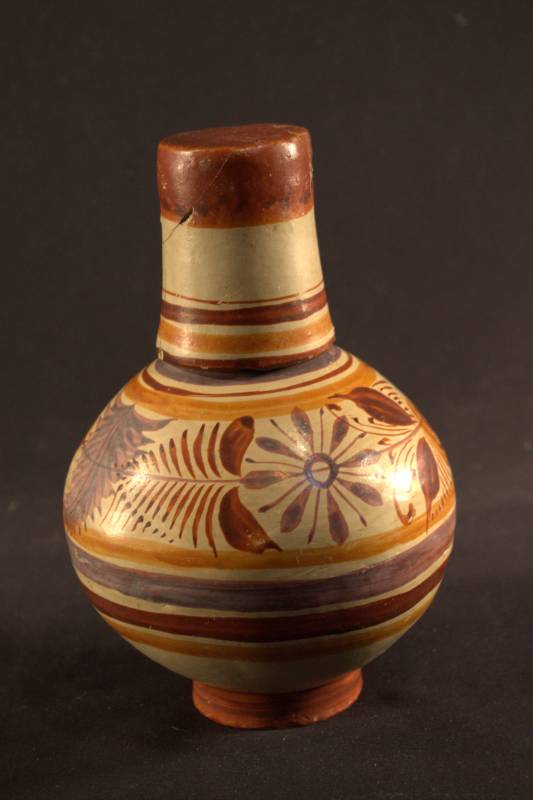 Jar Water jar and cup are colored cream with orange, red and purple stripes and flowers for decoration. The cup is placed on the top of the water jar like a lid.