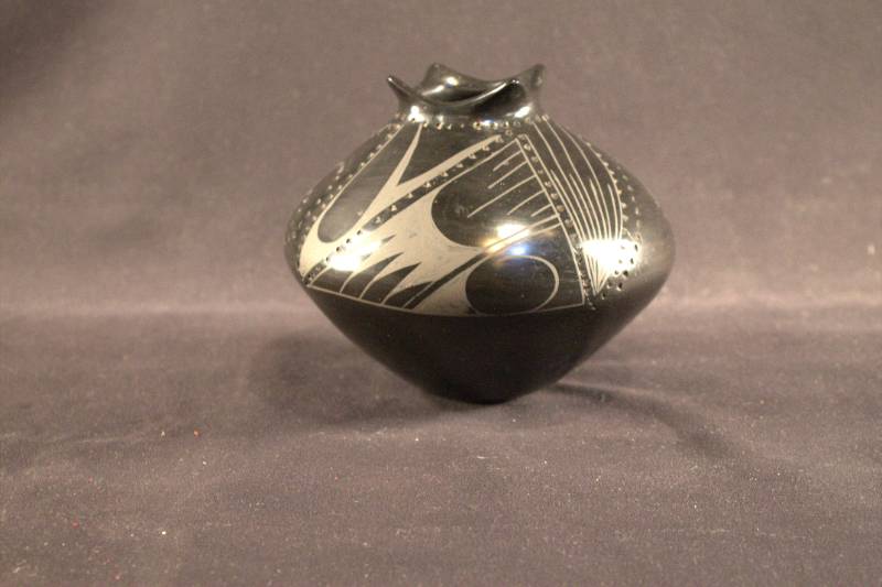 Jar Black jar with geometric designs on the top half.