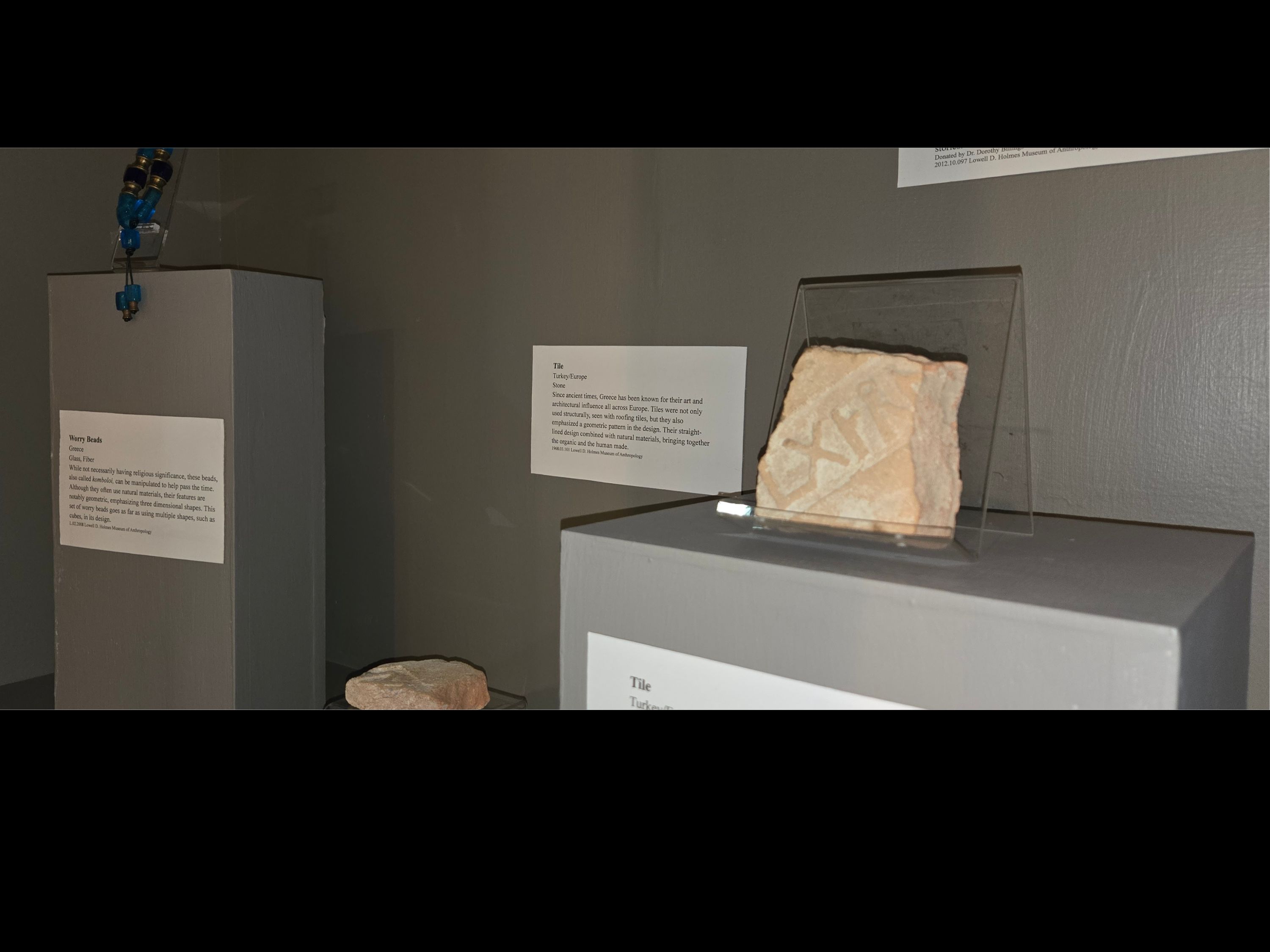 Case with a dark grey background and various objects on display.