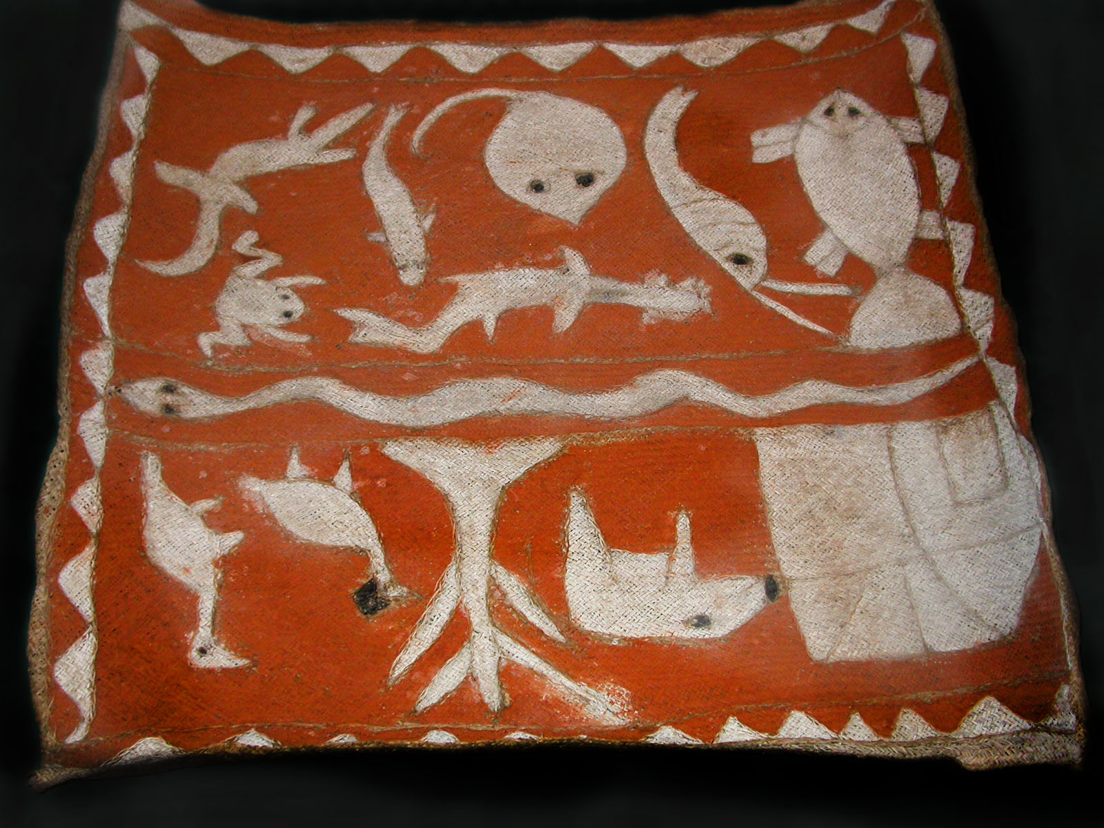 Rectangular mat made of plant fiber with designs of animals including, a wild boar, birds, eels, ray, and fish.