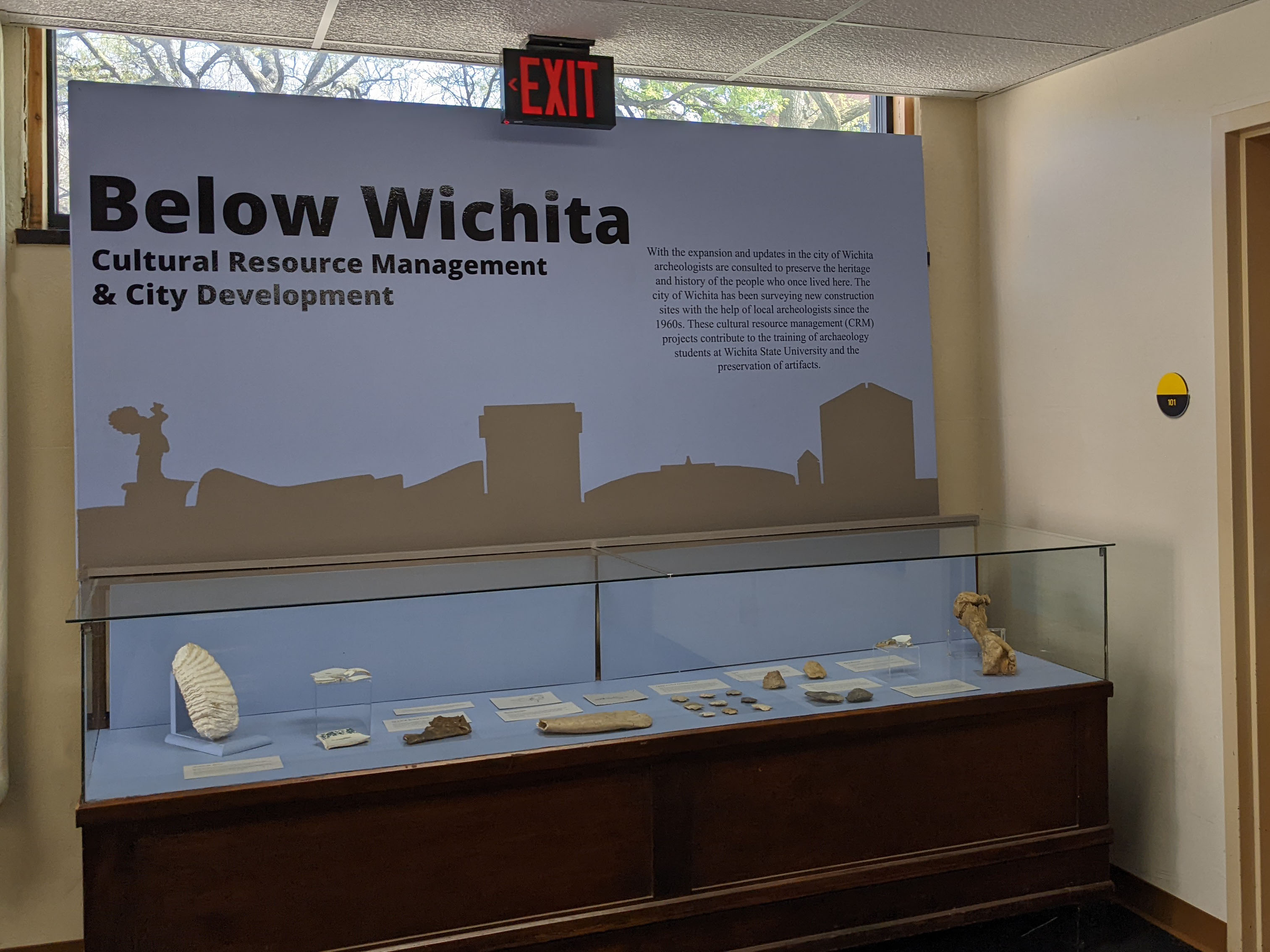 Exhibit case with objects inside. Title reads "Below Wichita: Cultural Resource Management & City Development".