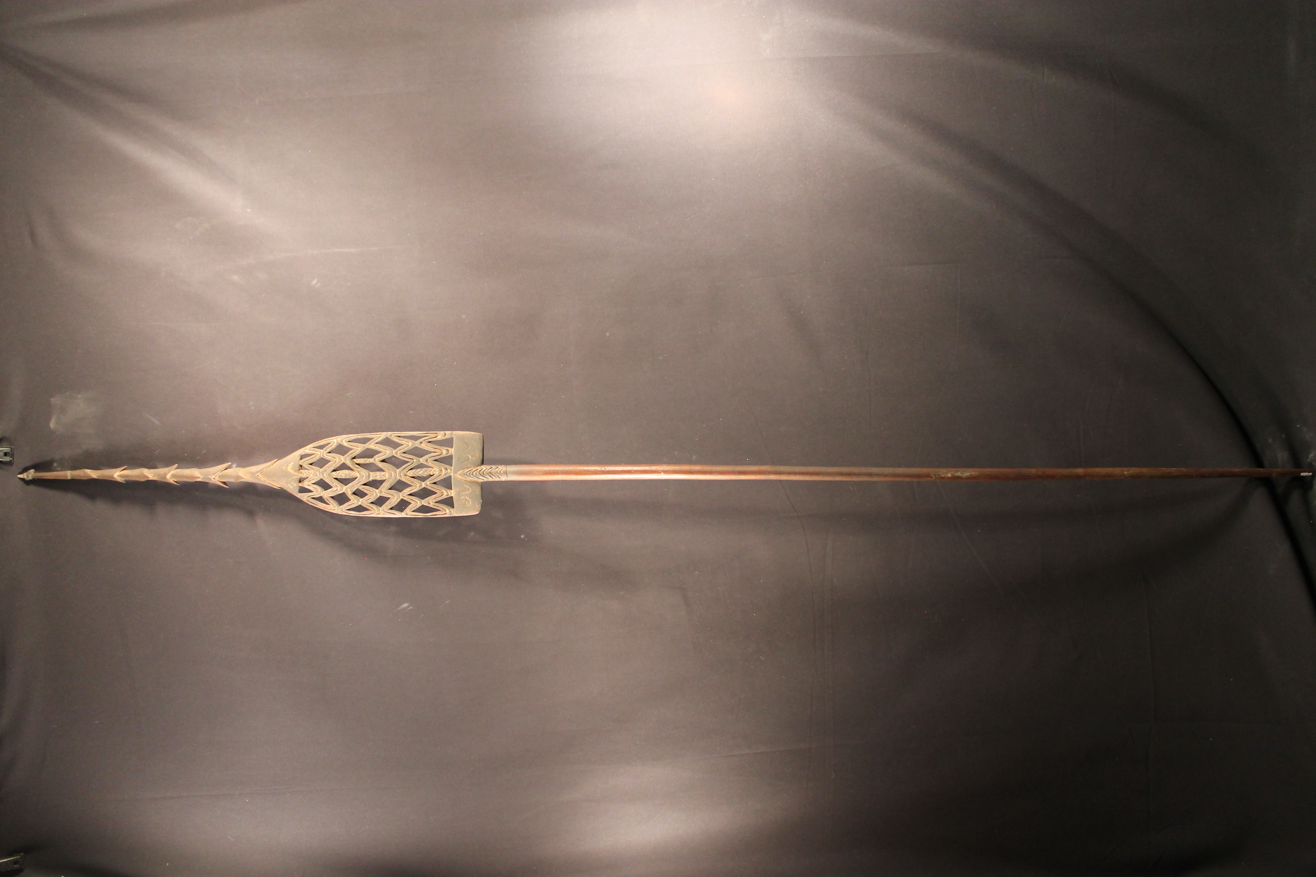 Carved wooden spear with barbs with carved panel center. 