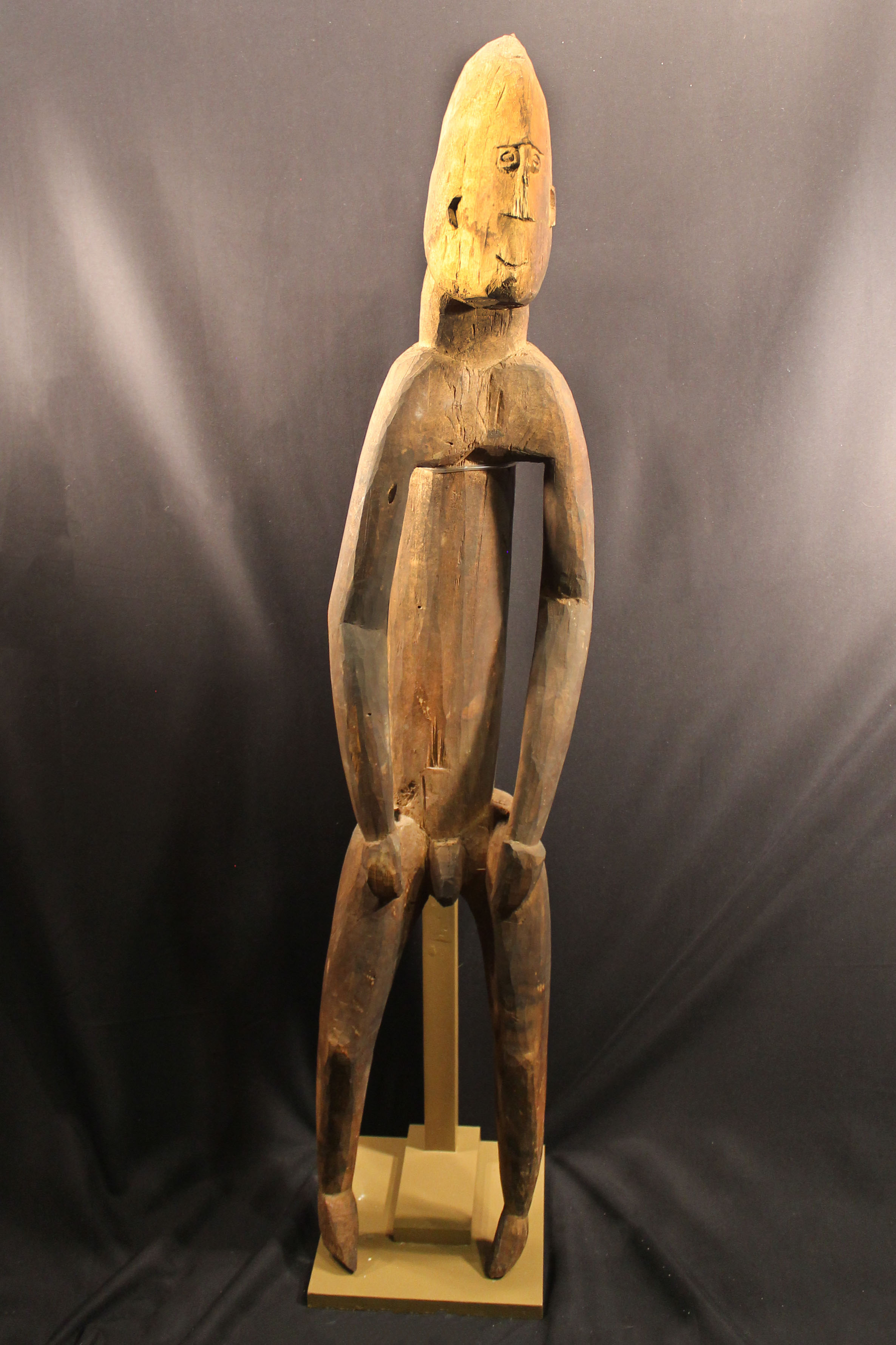 Darked brown carved wooden male figure.