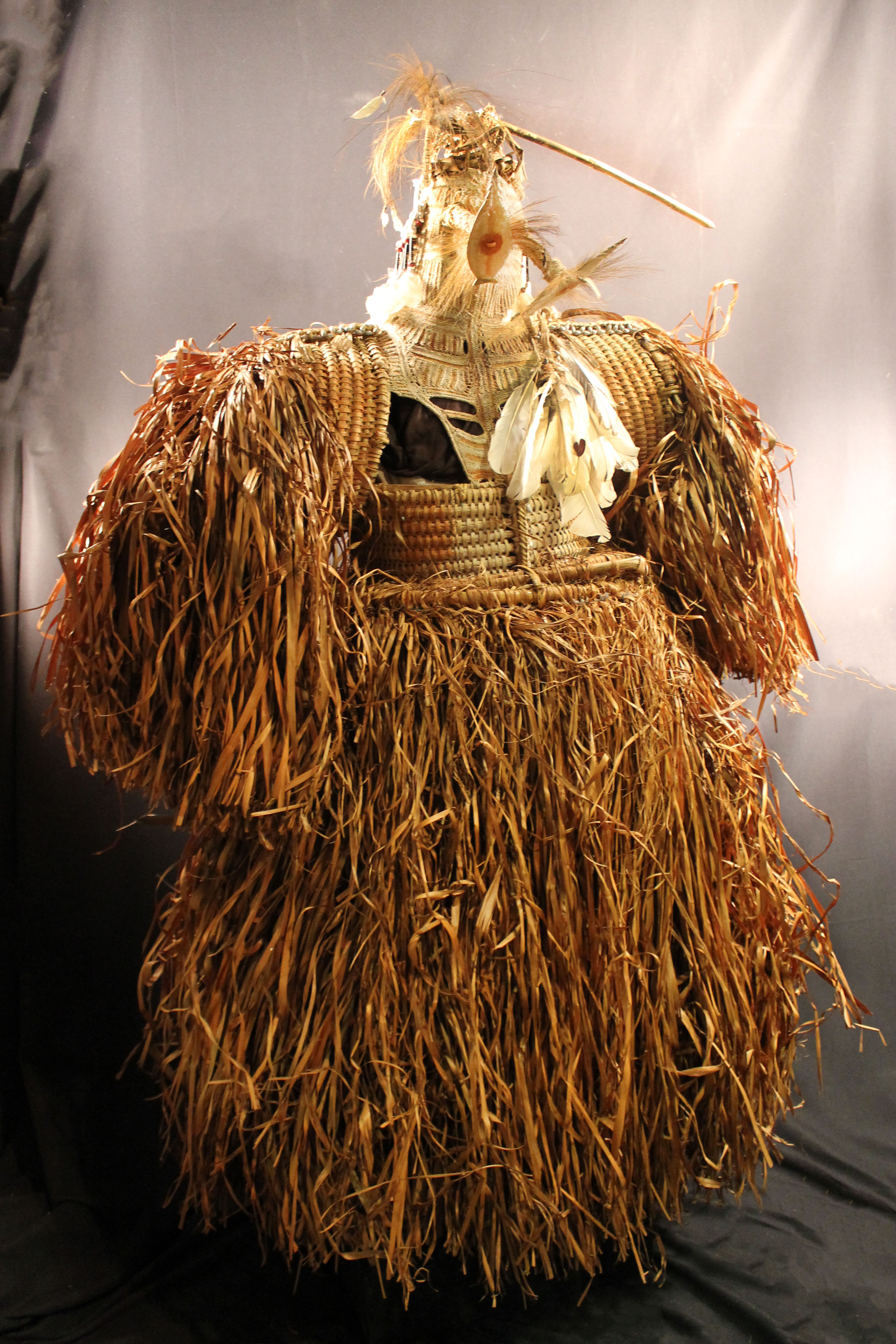 Woven body masks that has a grass skirt and sleeves with striped brown and white design on the center.