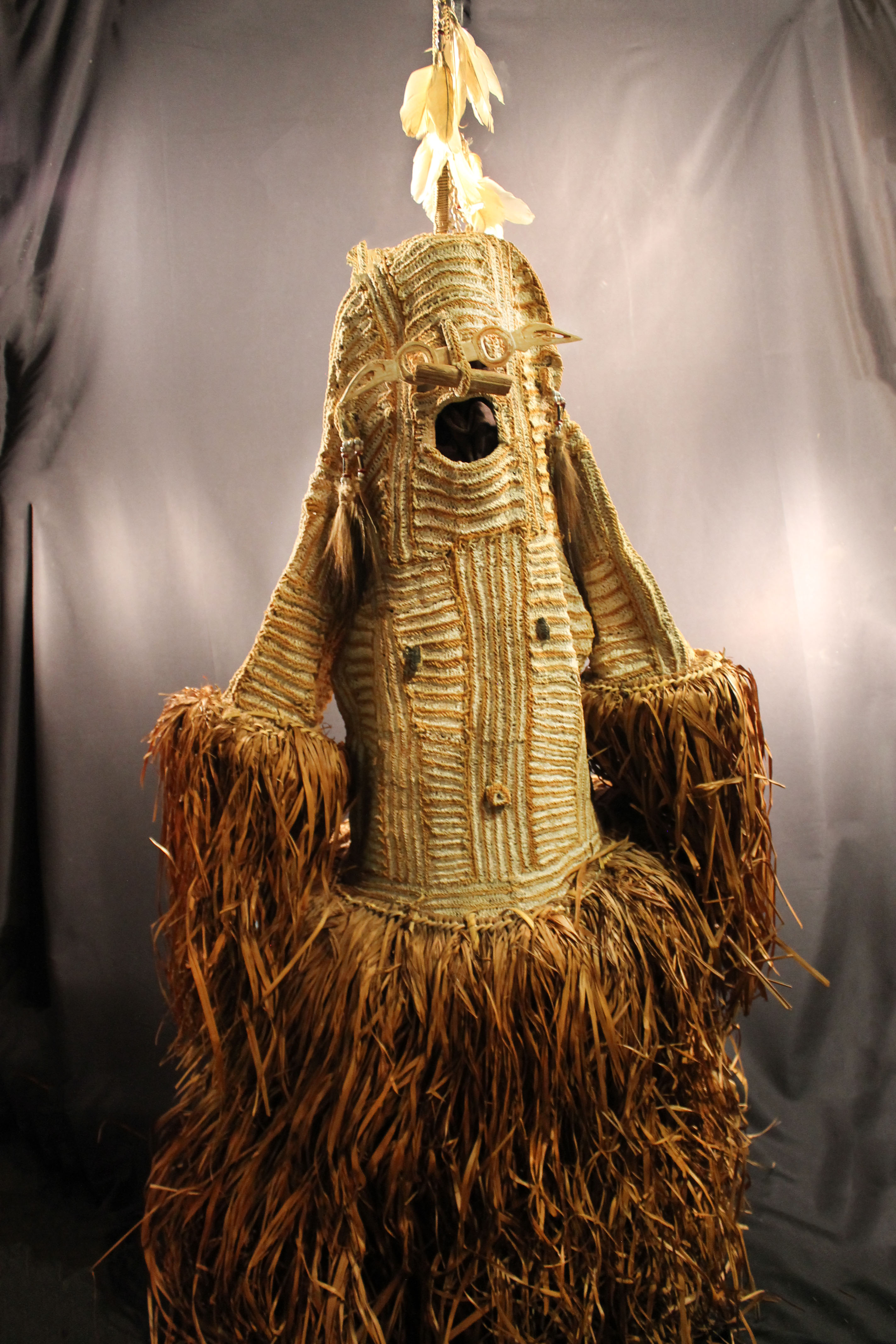 Woven body masks that has a grass skirt and sleeves with striped brown and white design on the center.