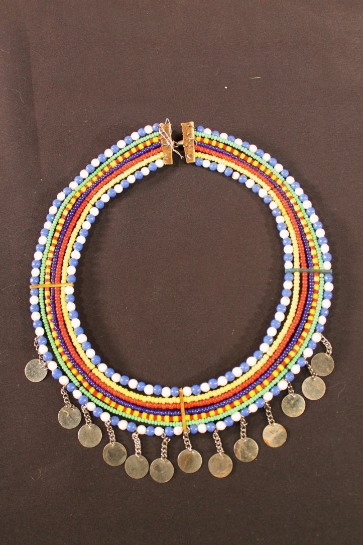Circular beaded necklace with strains of blue, white, green, yellow, red, and black beads with golden medallions handing off.