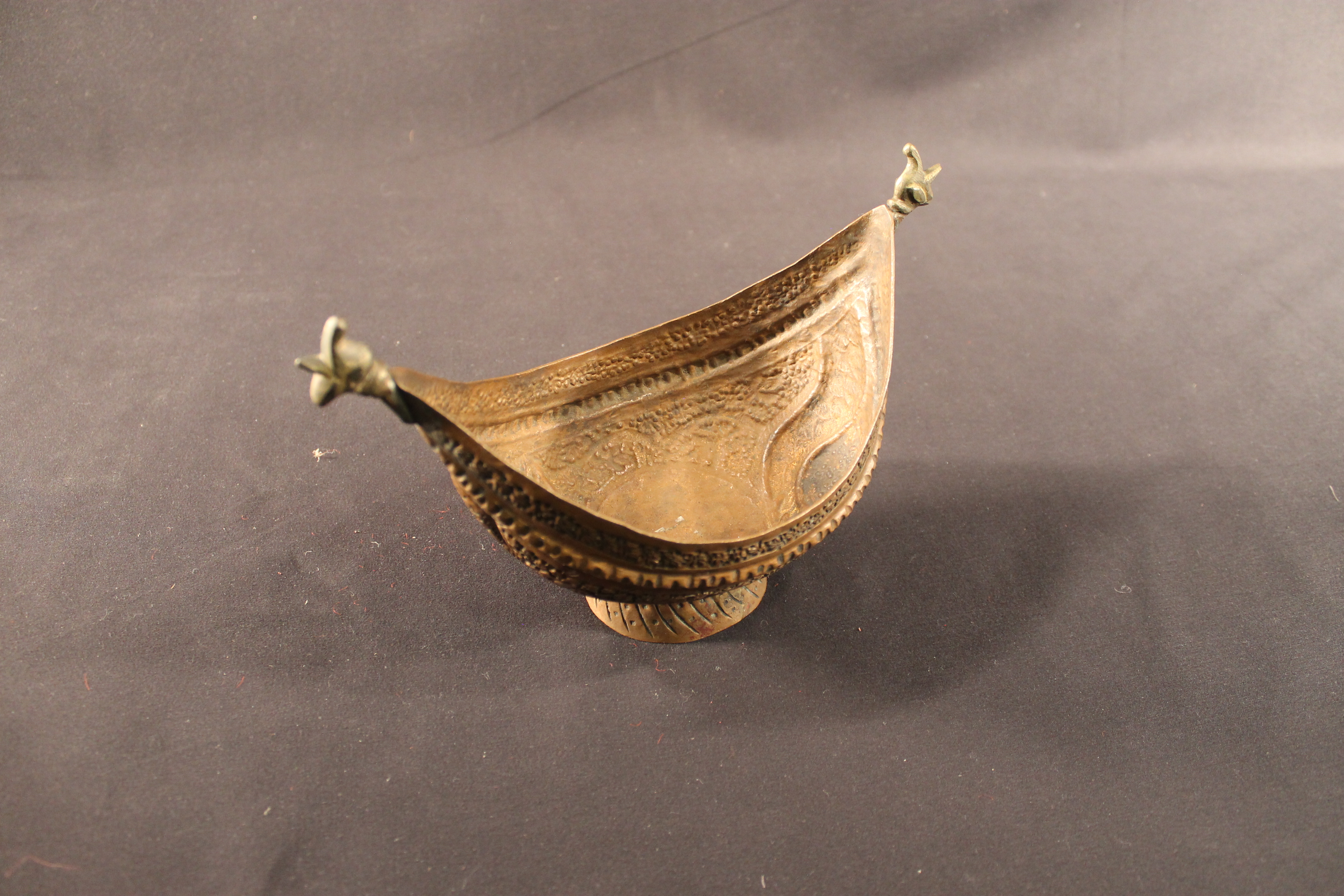 Copper bowl in the shape of a boat with a fine floral stencil design. 