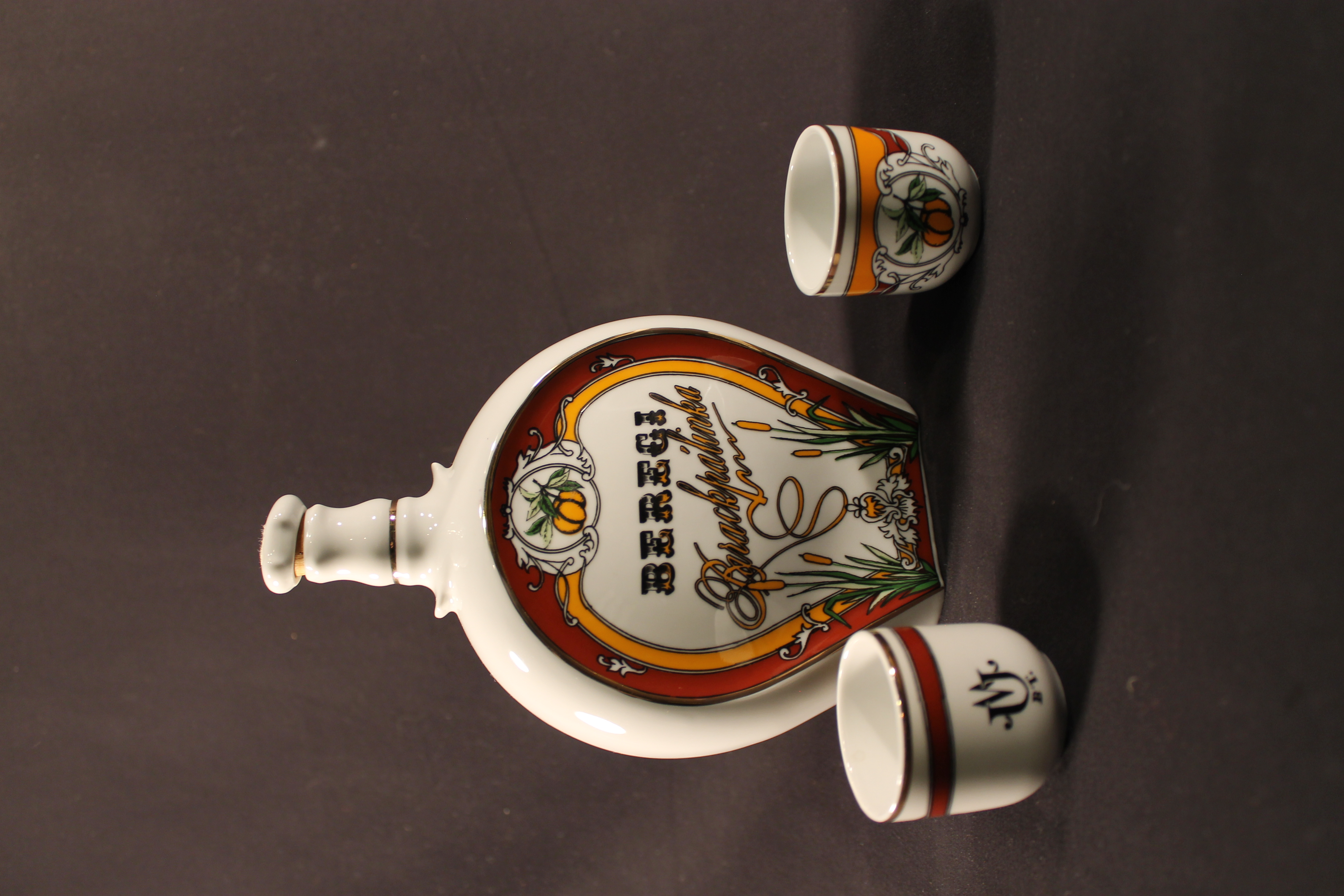 Beregi Palinka branded brandy decanter bottle with peaches on it. Two small glasses with the same peach design. 