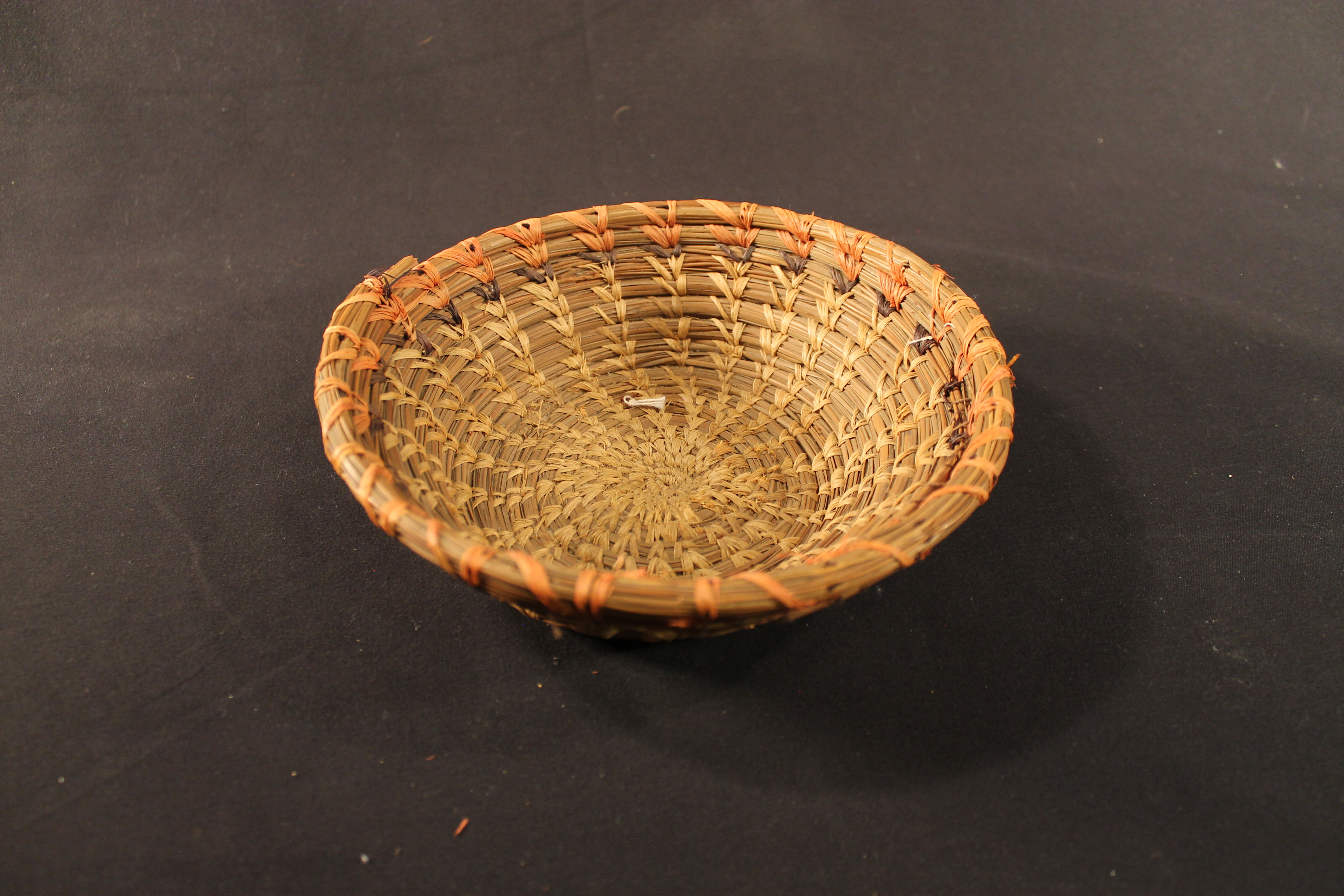 Coiled round pine needle basket.