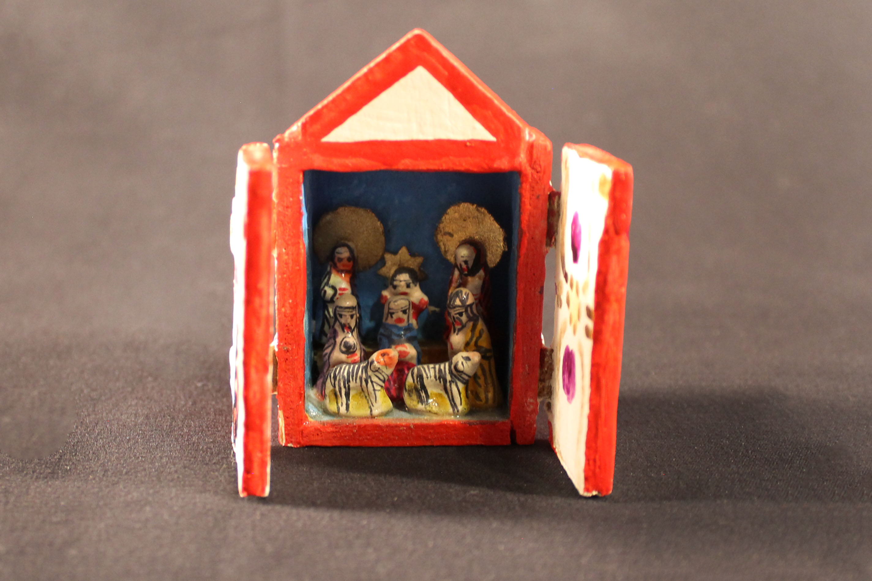 Mini wood nativity scene with two hinged doors that open to show six figures and two animals.