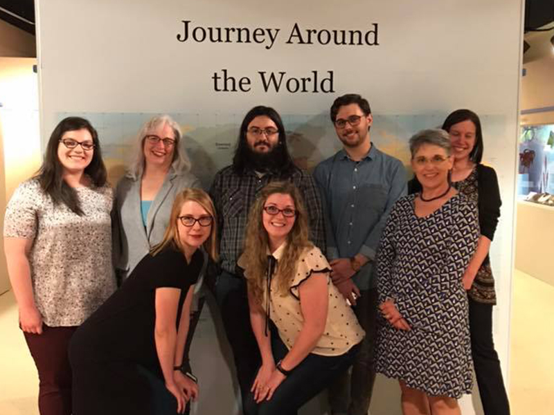 Museum Studies students pose in front of an exhibit they designed