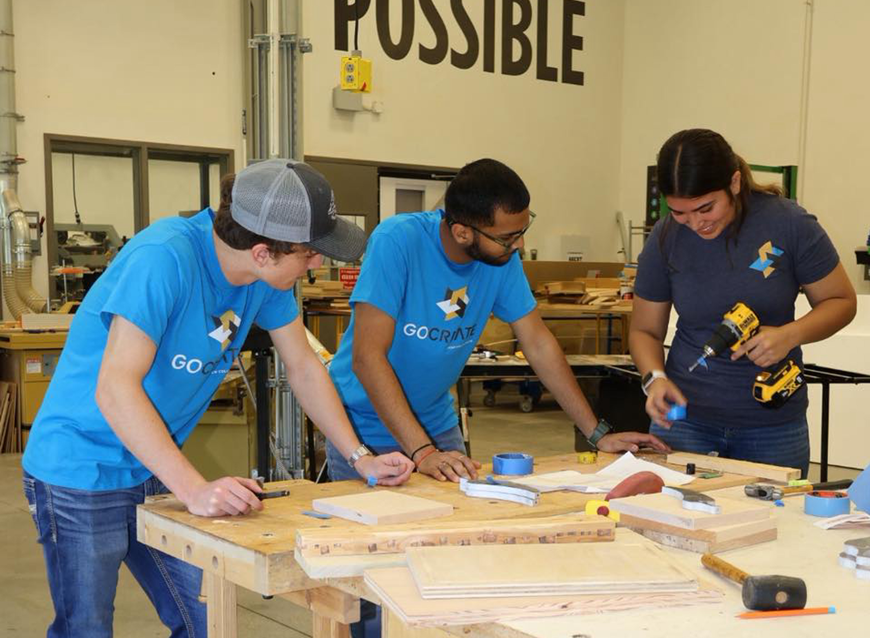 3 GoCreate mentors working at a wood table