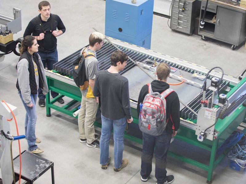 A group of people looking at machinery A group of people looking at machinery