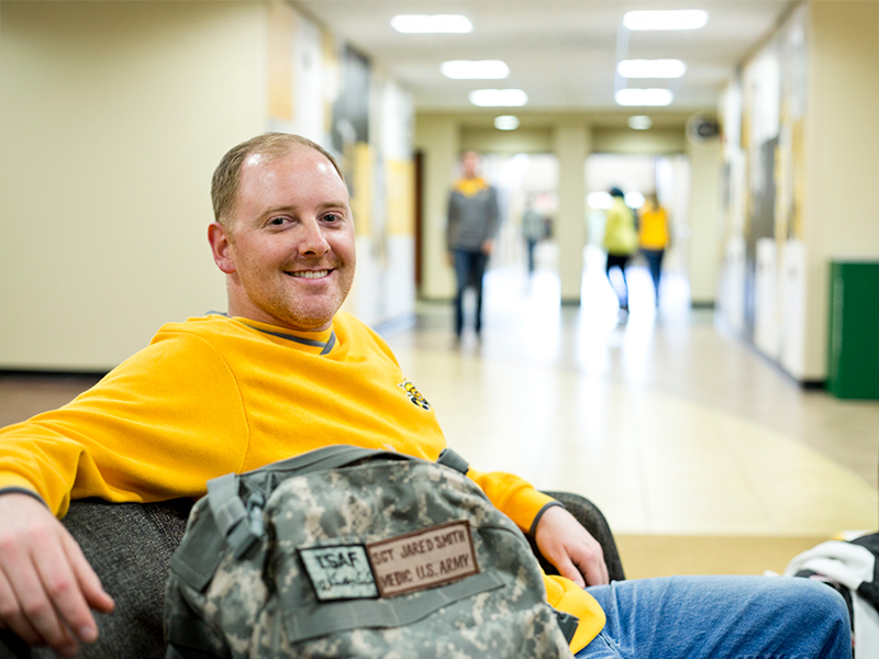 army student sitting in a hallway