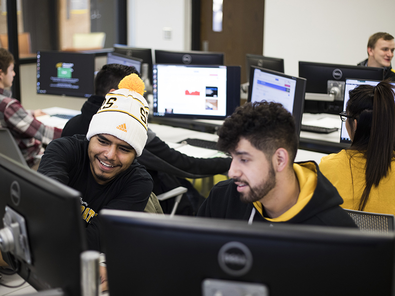 Two students work together in a computer lab in Clinton Hall