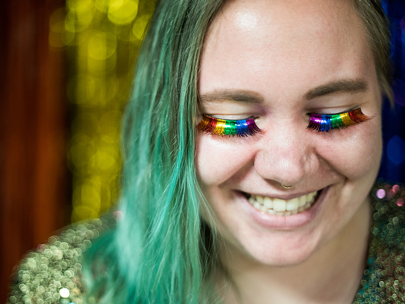 A student wearing rainbow-colored lashes at the annual Pride Prom.