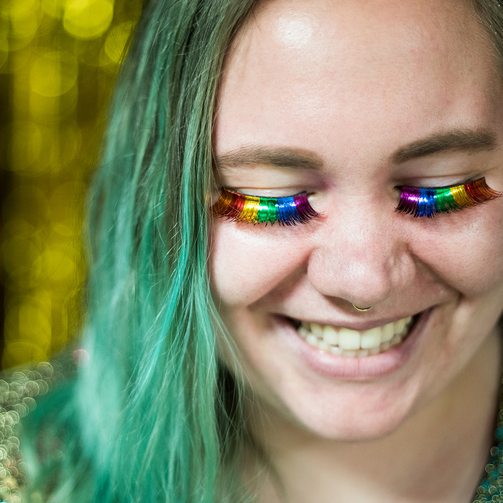 A student wearing rainbow-colored lashes at the annual Pride Prom.