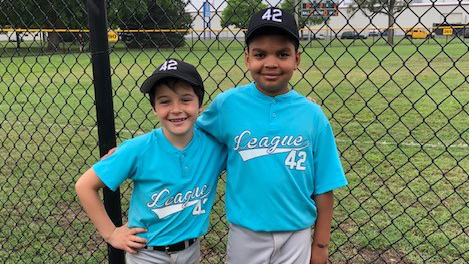 Two young male baseball players for League 42. 