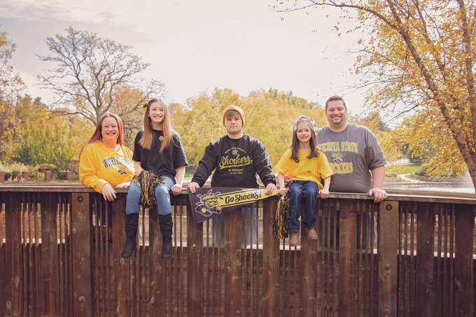 A smiling family on a bridge wearing Shocker gear.