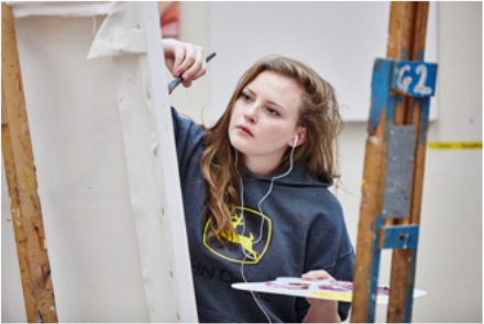 Student artist paints a canvas