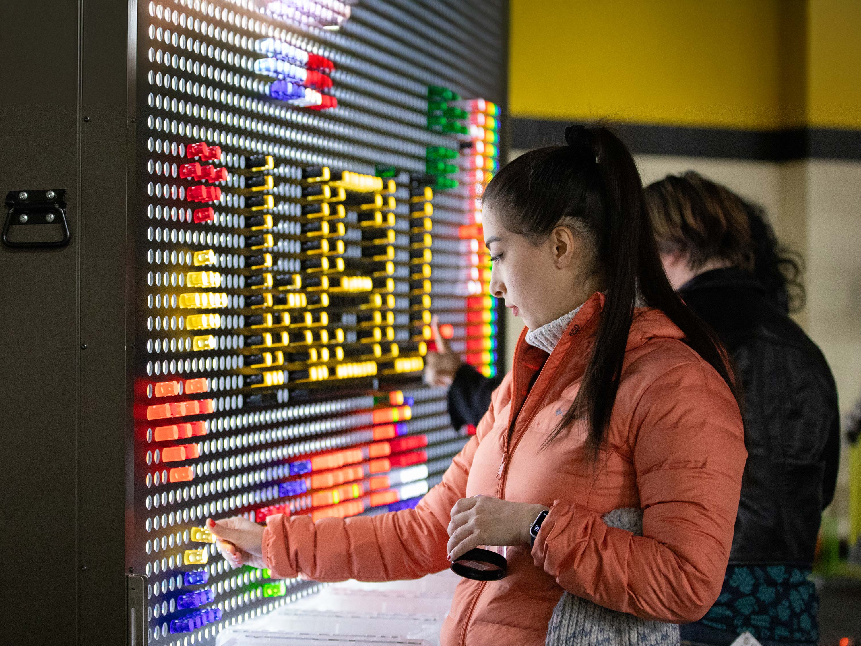 A student interacts with a giant light brite board.