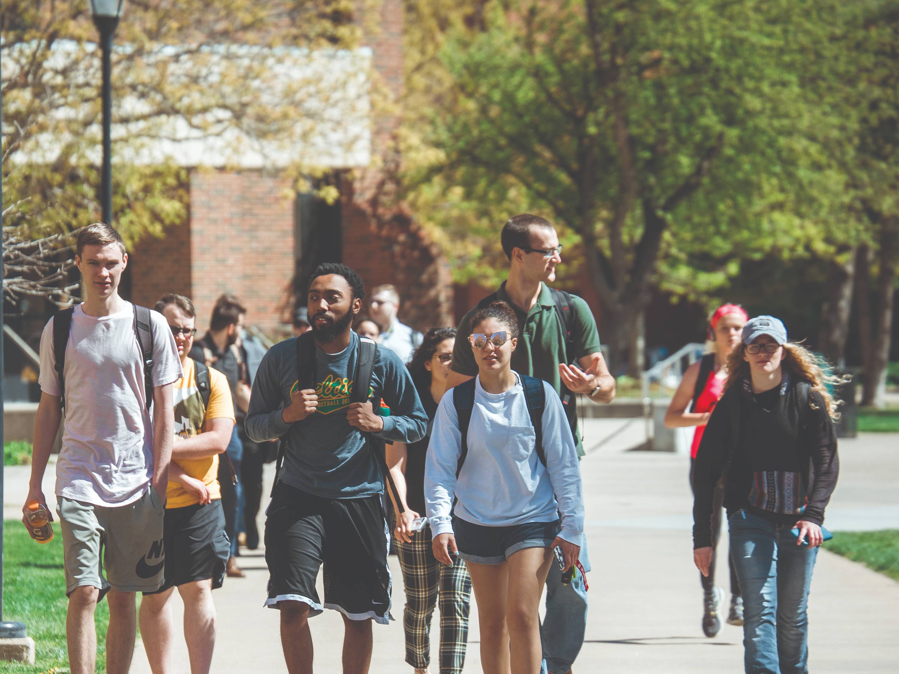 A group of students walk together on campus to their next class
