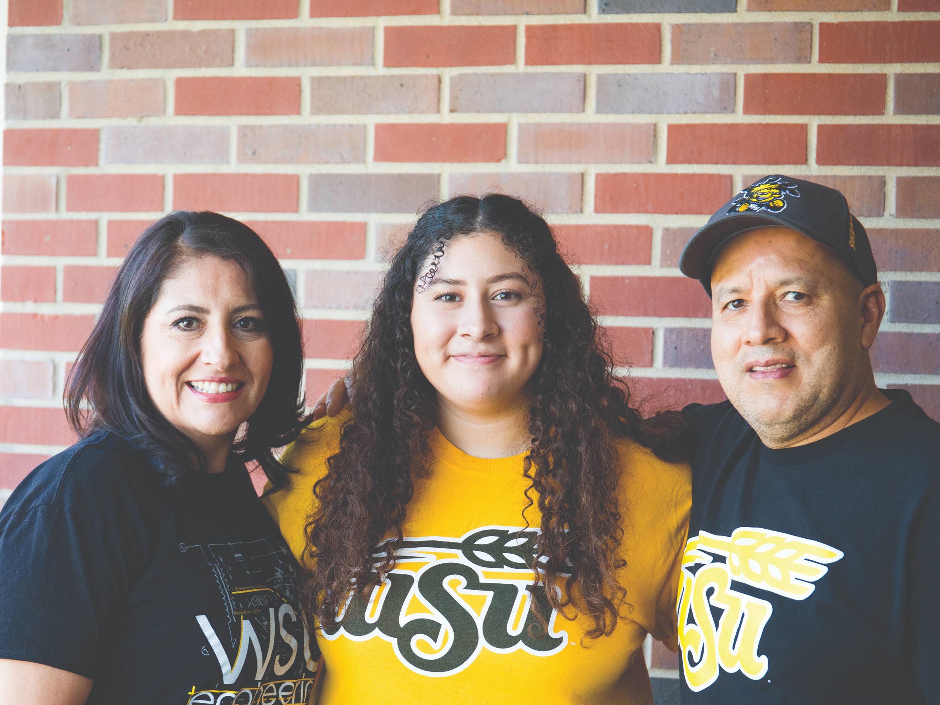 Two parents pose with their Shocker student