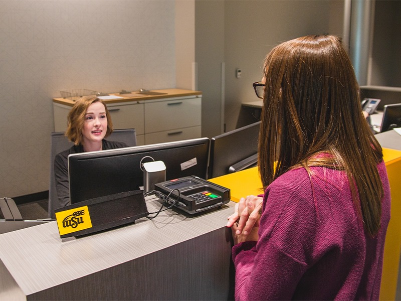 Student checking in at front desk of Student Wellness Center