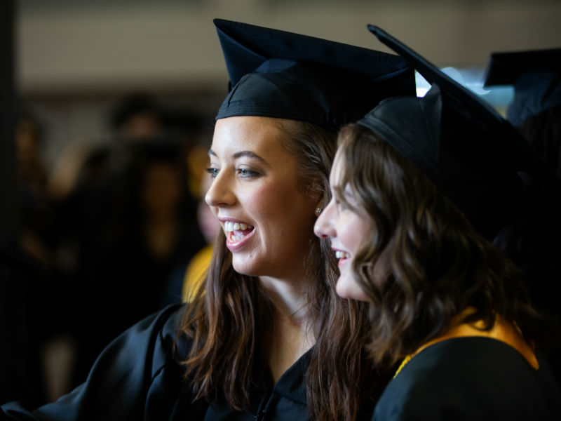 two females in graduation regalia