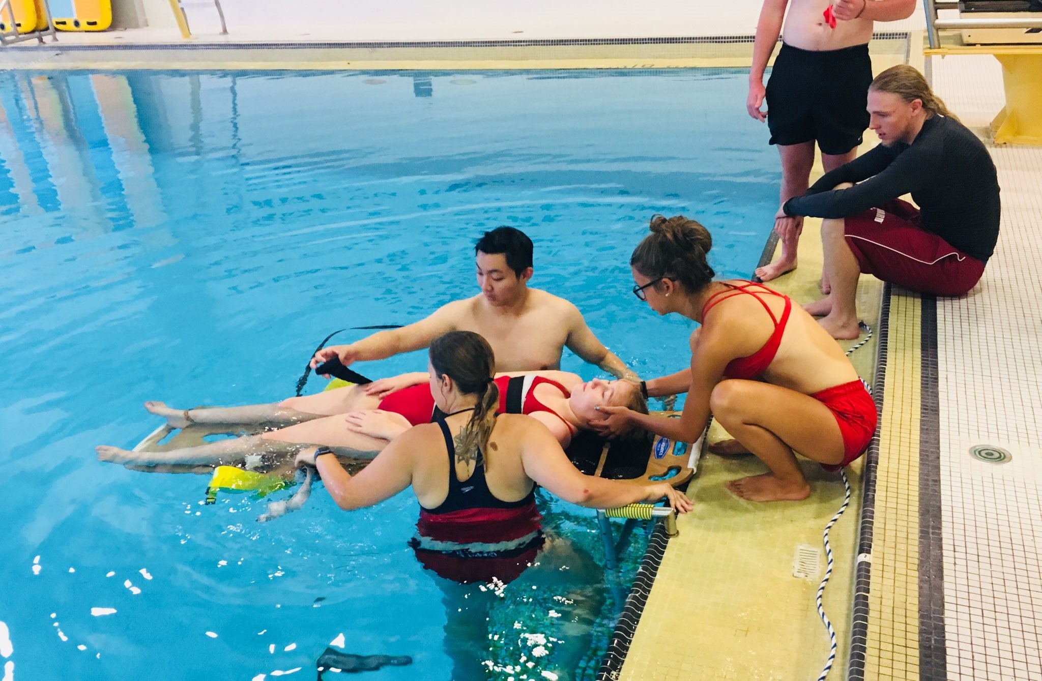 Lifeguards performing practice pool rescue