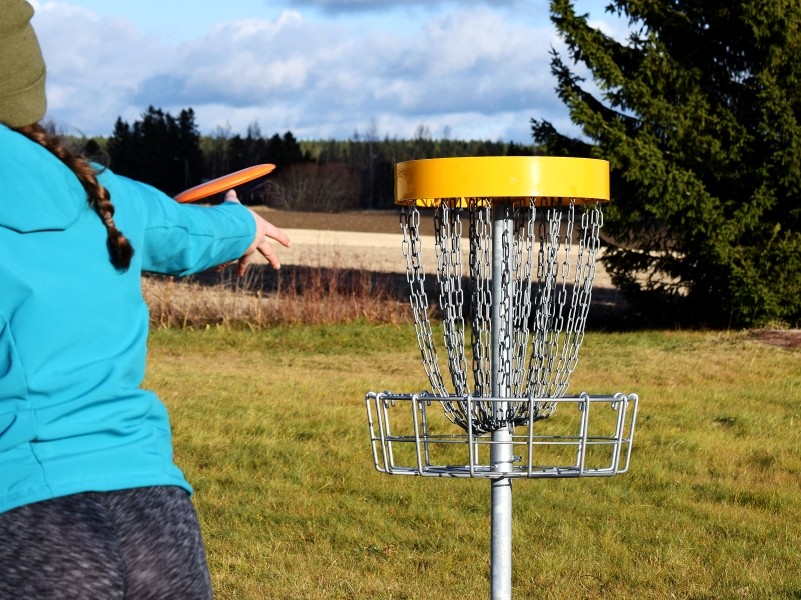 Student sending her disc toward the disc golf hole