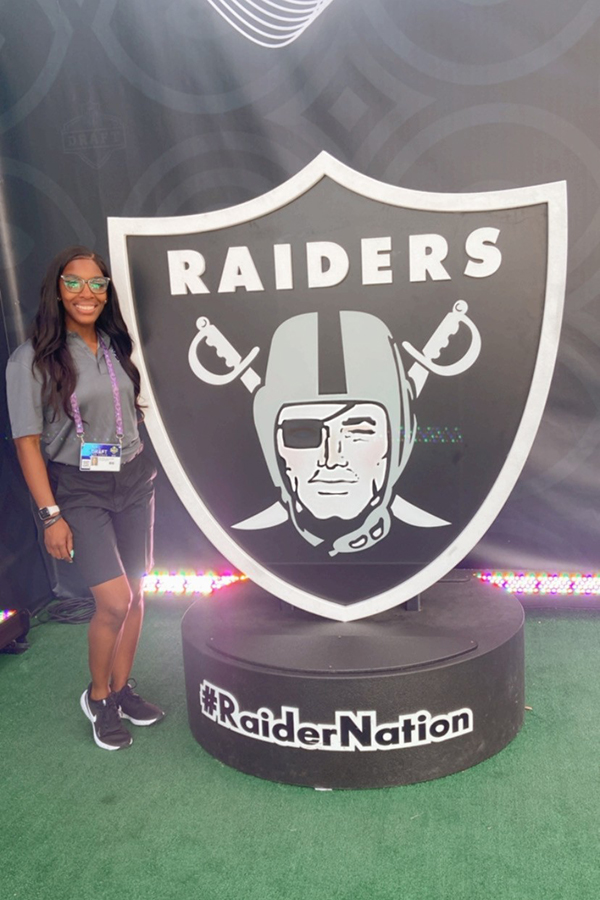 Daysha Bullocks stands with Raiders memorabilia