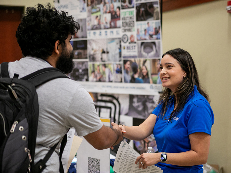 employer shakes students hand at the Engineering & I.T. Career Fair